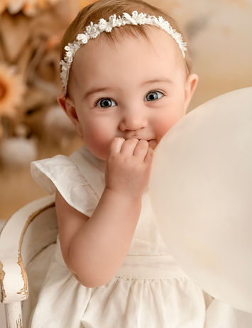 Portret van meisje tijdens cakesmash fotoshoot voor haar eerste verjaardag in Sint-Pauwels.