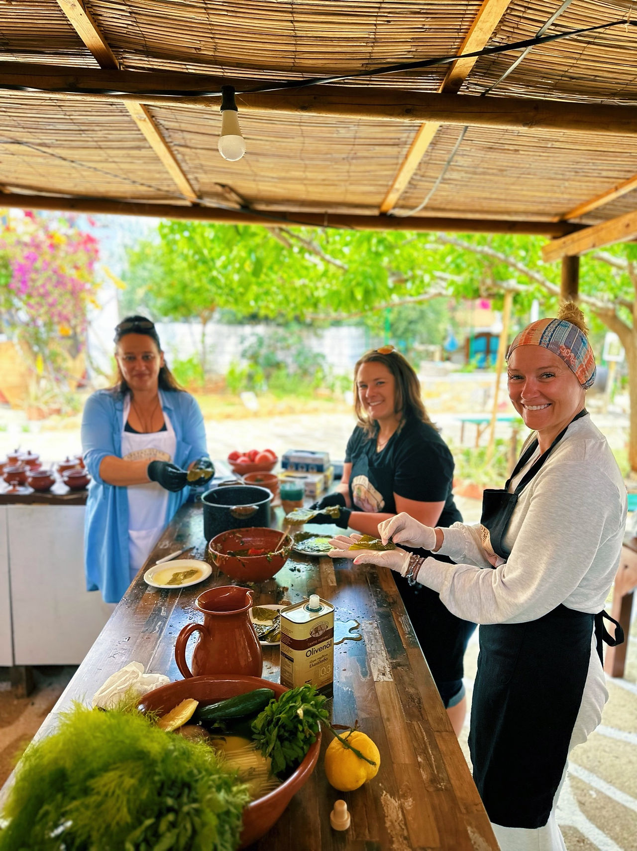 young adult friends in their 30s smiling and cooking together on a group travel trip