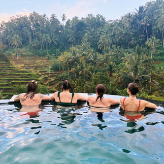 FTLO travelers relaxing in an infinity pool overlooking Bali rice terraces during a group travel exp