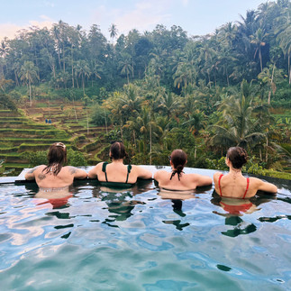 FTLO travelers relaxing in an infinity pool overlooking Bali rice terraces during a group travel exp