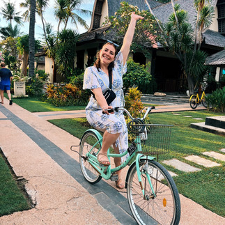 FTLO alumni traveler Miranda riding a bicycle through tropical gardens during a Bali group trip in Southeast Asia.