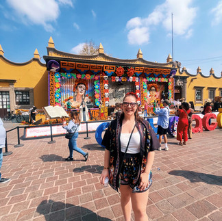 FTLO alumni traveler Miranda exploring colorful Day of the Dead decorations in Mexico City during an FTLO group trip.
