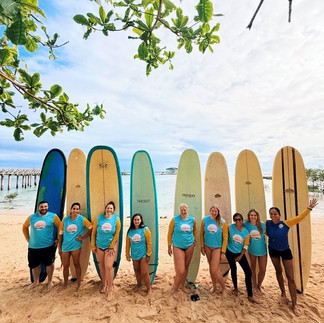 FTLO travelers posing with surfboards on the beach during an adventure-filled Bali group trip.