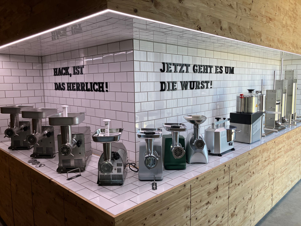 Showroom Landig mit Fleischwölfen vor weißer Kachelwand.