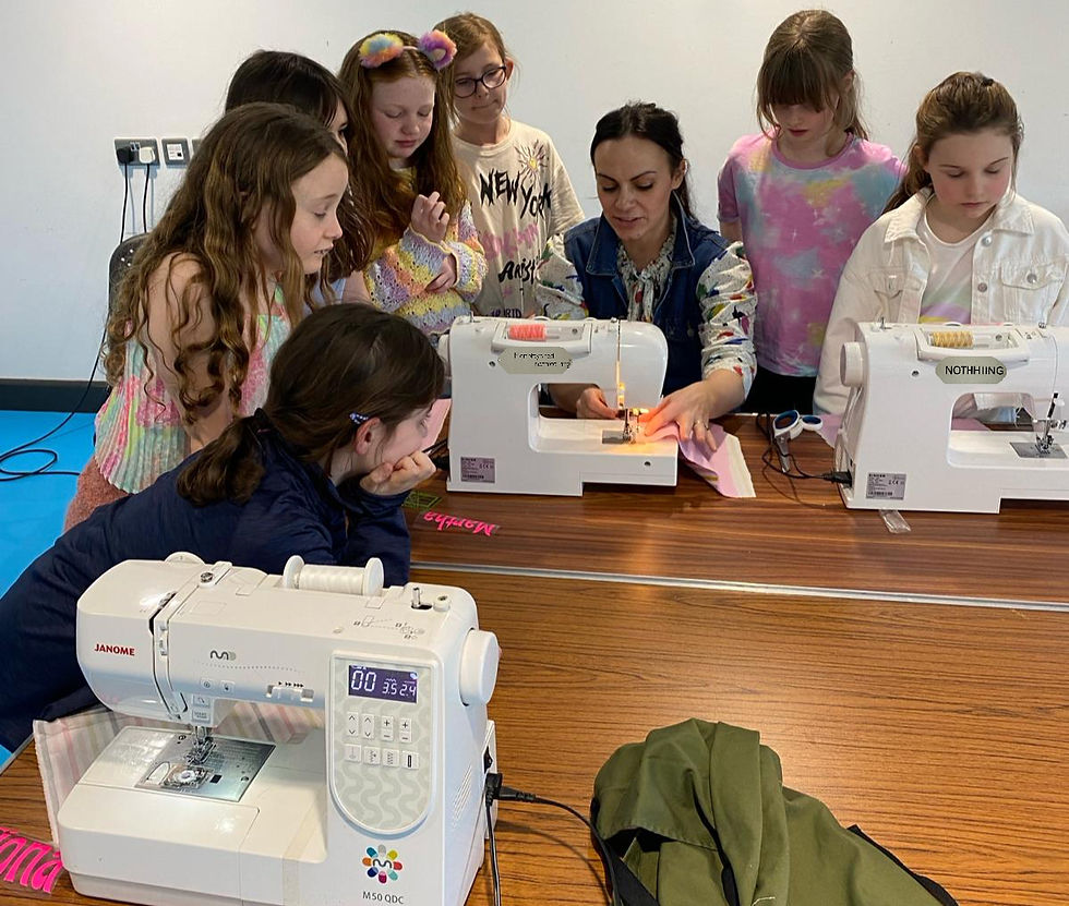 Angeline teaching a group of young girls to sew