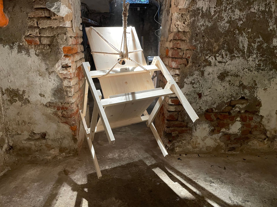 Installation by Antonio Scarponi: innocent chair suspended with a rope projecting shadows on the floor