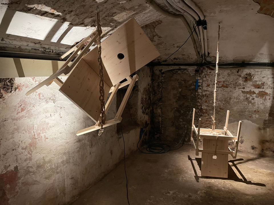 Installation by Antonio Scarponi: innocent chairs suspended with a rope projecting shadows on the floor and walls