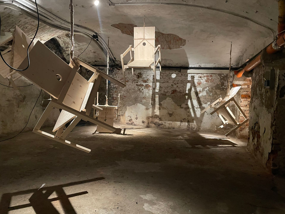 Installation by Antonio Scarponi: innocent chair suspended with a rope projecting shadows on the floor and wall