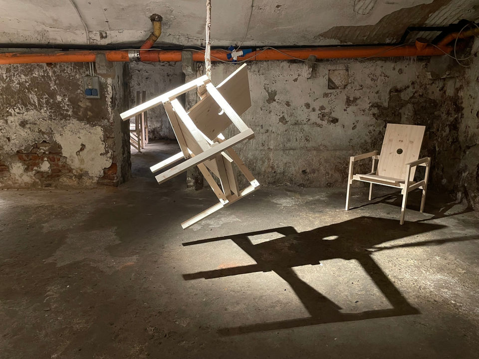 Installation by Antonio Scarponi: innocent chairs suspended with a rope projecting shadows on the floor