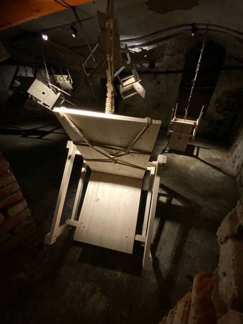Installation by Antonio Scarponi: innocent chairs suspended with a rope projecting shadows on the floor and walls