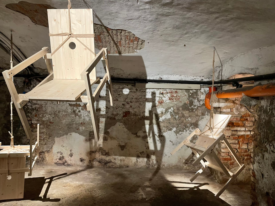 Installation by Antonio Scarponi: innocent chairs suspended with a rope projecting shadows on the floor and walls