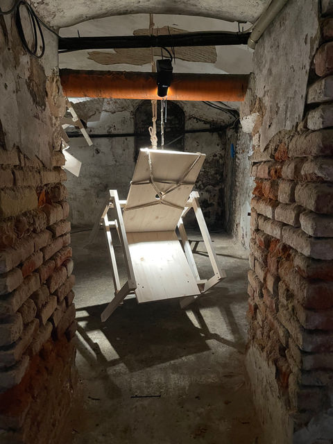 Installation by Antonio Scarponi: innocent chair suspended with a rope projecting shadows on the floor