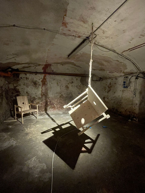 Installation by Antonio Scarponi: innocent chairs suspended with a rope projecting shadows on the floor and walls