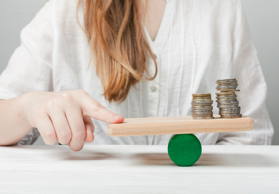A woman skillfully balances stacks of coins on a small wooden platform, demonstrating precision and focus.