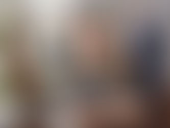 Two people in an office discussing a document on a tablet. Both wear glasses and business attire. The mood is focused and serious.