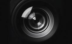 A black and White image showing a close up of the front of a lens of a TV camera .jpg