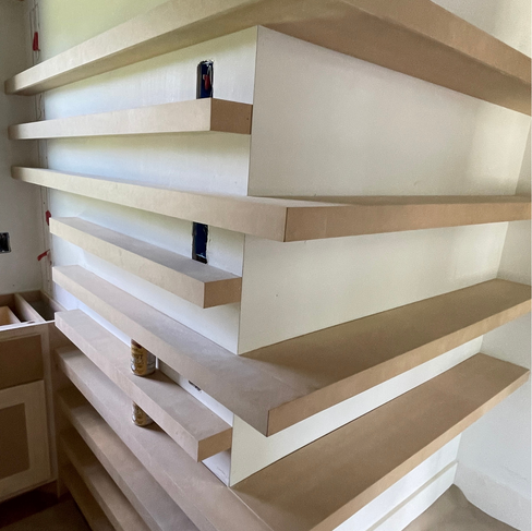 Small corner-wrapped floating shelves that have not yet been painted.