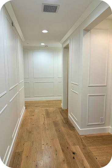 A corridor of a home has been updated with simple library paneling.