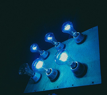 Imagen Azul de una placa con seis ampolletas que iluminan la oscuridad. Todas encendidas, menos una.