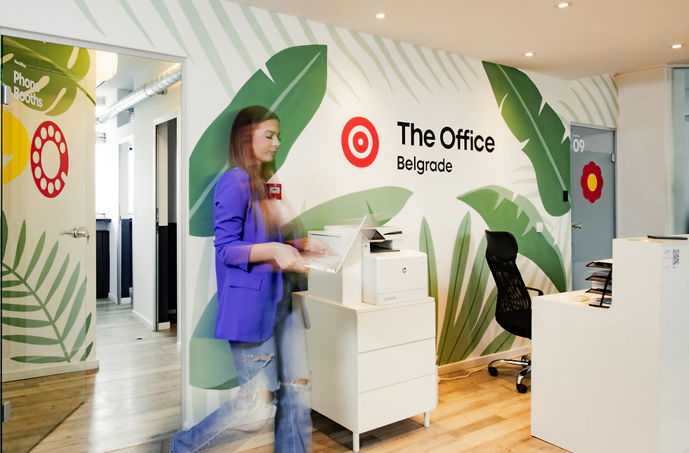The Office Belgrade coworking space reception with branded wall, phone booths and modern workspace environment in Belgrade Serbia