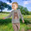 Thumbnail: Young child smiling, wearing gray bear shirt in field, 