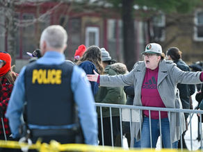 Manifestantes reunidos en una protesta pacífica frente a un edificio gubernamental en Minneapolis tras el tiroteo de un agente de inmigración, con pancartas a favor de los derechos humanos y la reforma migratoria.