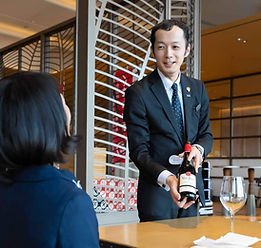 ワインをお客様に説明する料飲サービス部門スタッフ