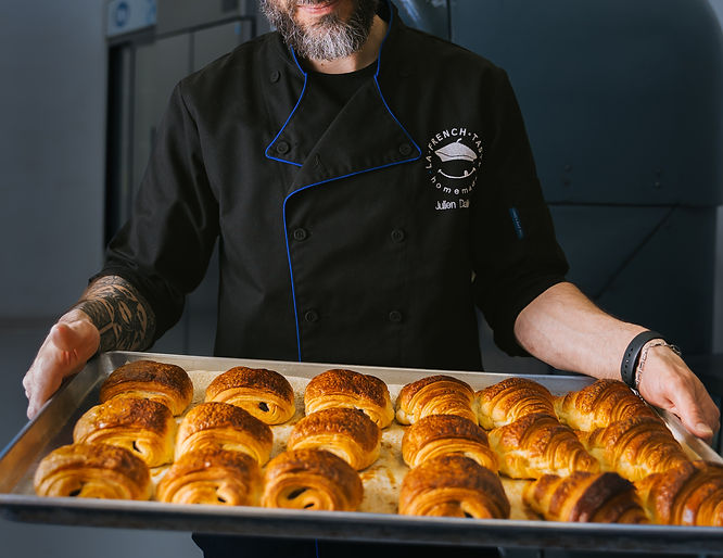 Julien, co-founder of La French Taste, holding a tray of pains au chocolat