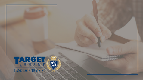 Zapisywanie notatek w notesie obok laptopa