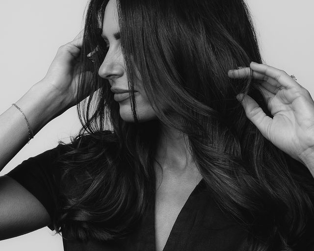 Middle-aged female hairstylist playing with her hair
