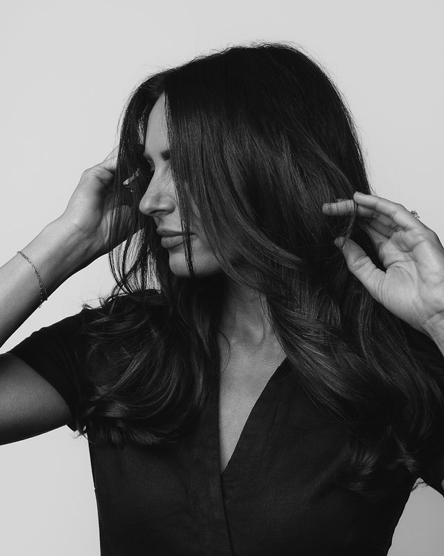 Middle-aged female hairstylist playing with her hair