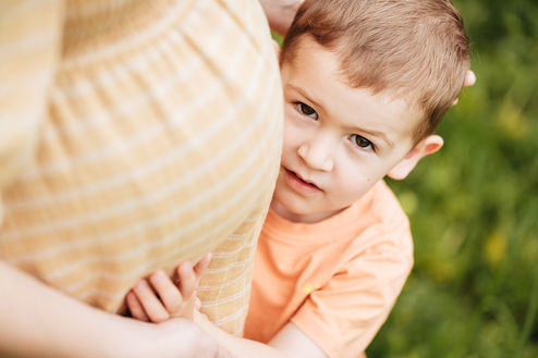 Kleiner Junge umarmt schwangeren Bauch