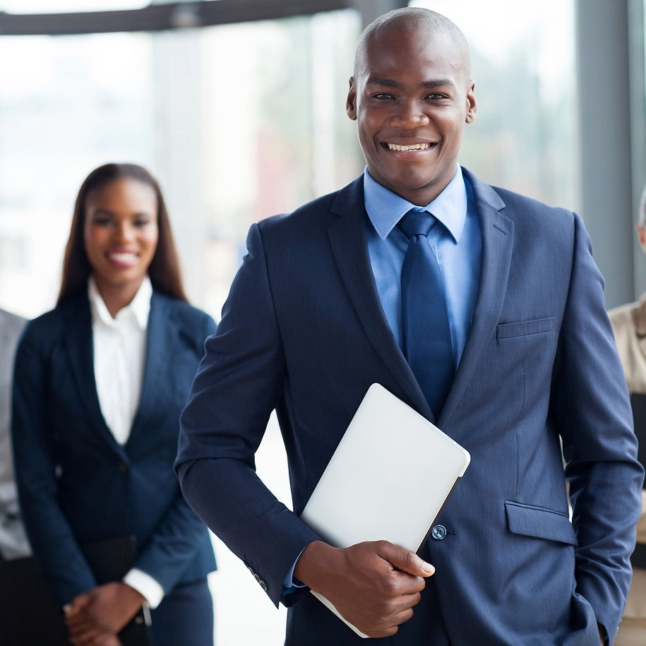 handsome african businessman with group of businesspeople on background.jpg