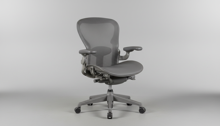 Eye-level view of a clean used task chair in a neutral studio setting.