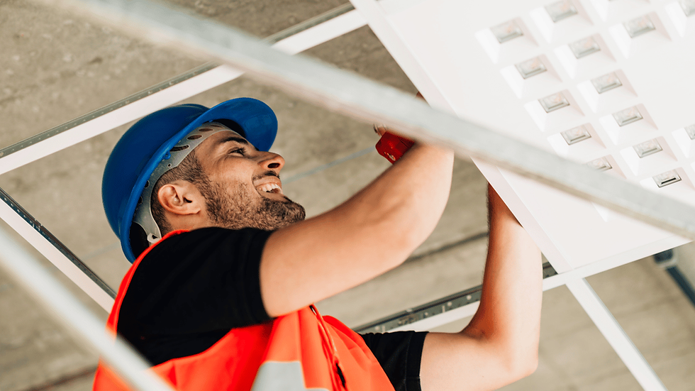 Man in a blue hard hat working on a home project

