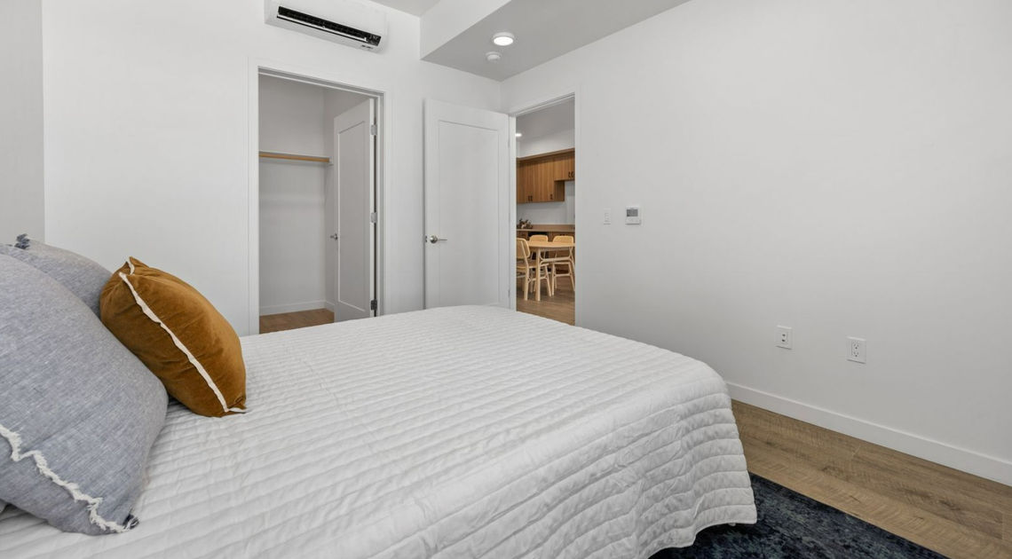 bed with white cover and brown pillow