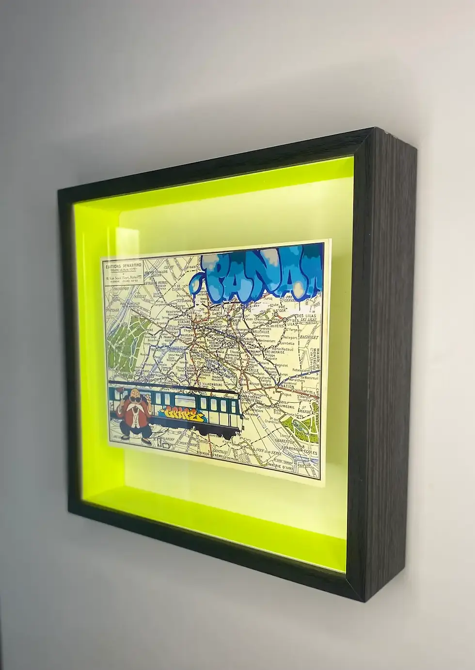 Affiche encadrée moderne et contemporaine mêlant carte du métro de Paris, graff multicolore et personnage cartoon urbain.  