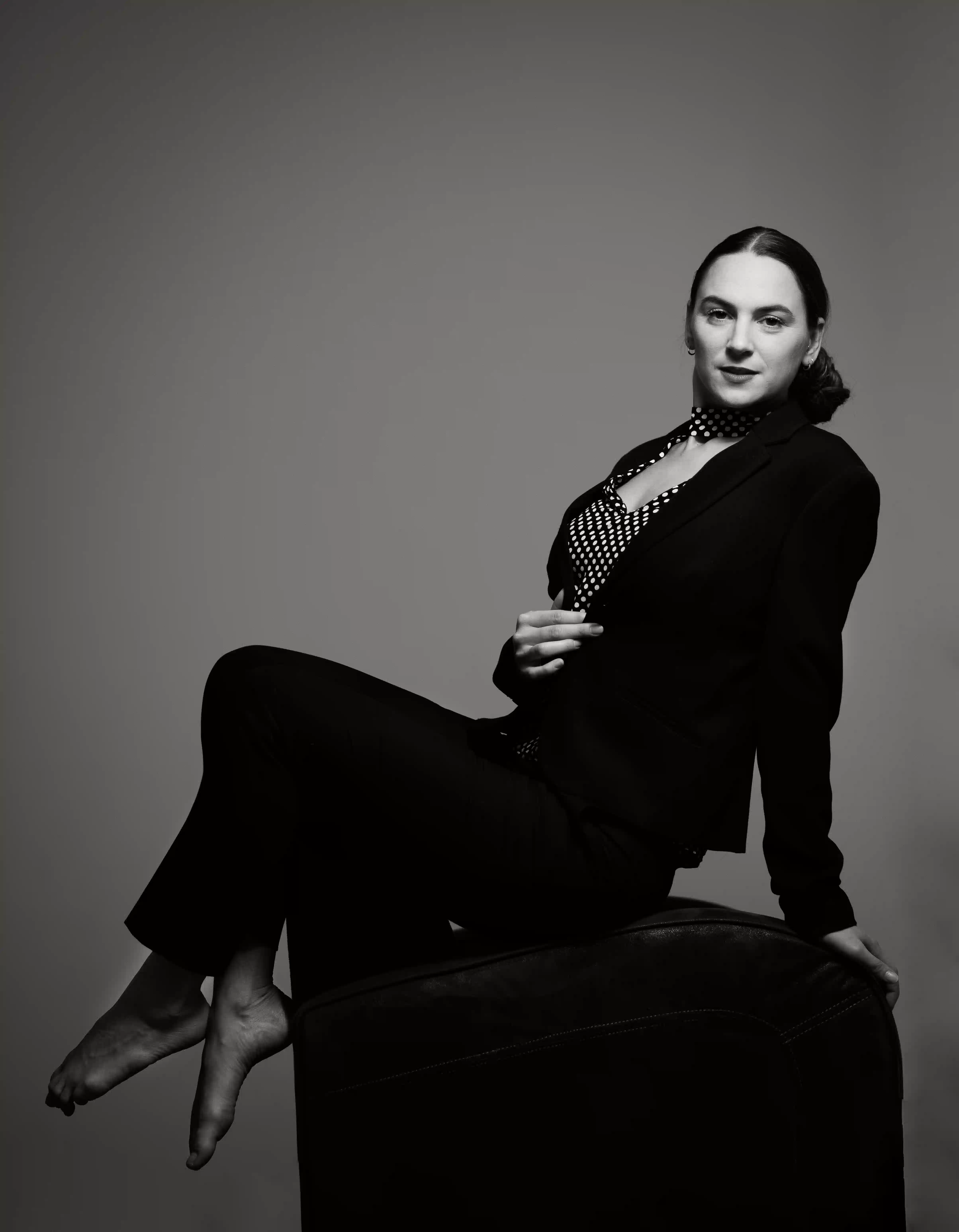Norah Nousche est assise de côté, les jambes croisées, et nous regarde de face.