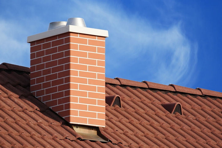 Brick chimney on a red tile roof