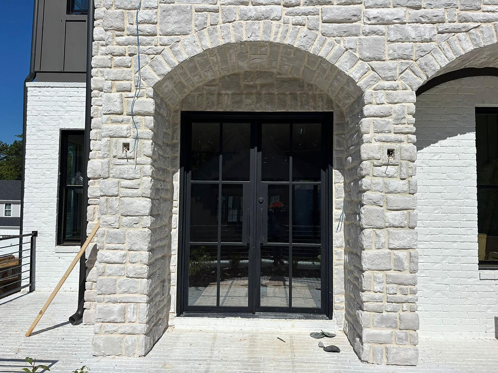 Custom stone masonry entryway featuring natural stone installation and detailed arch design for a high-end residential project.