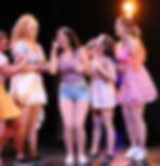 Performers singing and dancing at Wohlfahrt Haus Dinner Theatre