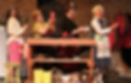 Performers singing and dancing on stage at the Wohlfahrt Haus Dinner Theatre
