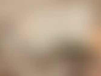 Sala moderna con sofás blanco y verde, mesa central, alfombra beige, ventana amplia con persianas, mano control remoto, arte abstracto. Ambiente acogedor.