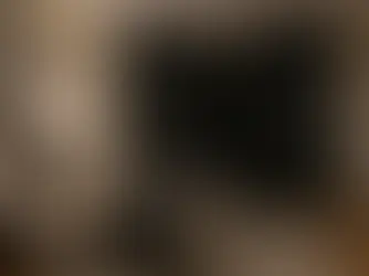 Dormitorio acogedor con cama doble, colchas grises, lámparas de noche encendidas. Cortinas oscuras y cuadro abstracto en la pared.