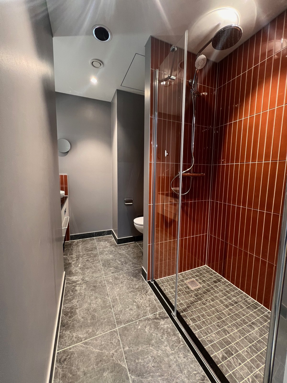 Fertig verfliestes Bad mit Dusche und WC
