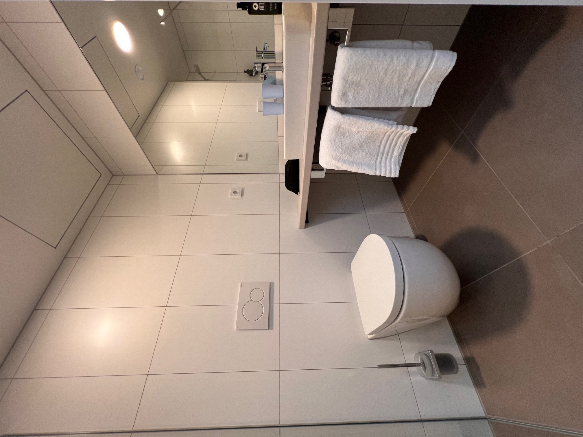 Hotelbad mit wandhängendem WC, Waschtisch und Spiegel