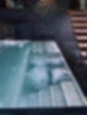 piscina-jacuzzi de hormigón armado a medida.
Se observa la piscina de noche iluminada. la pared es a juego con el resto del color grisáceo oscuro, fusionando la piscina con la pared. Es una imagen real de una obra hecha por la empresa, muy relajante y estimulante al mismo tiempo.