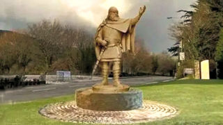 Livros Vikings | Estátua estilizada de um guerreiro nórdico apontando para o horizonte em um campo gramado. — Crédito da Imagem: BBC News / Darren Jackson & Stephanie Quayle-Jackson.