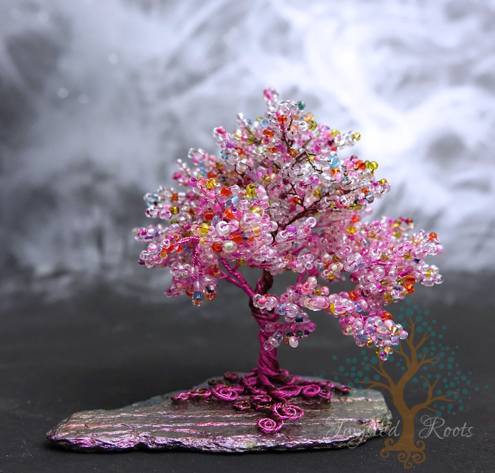 Pink bead and wire tree sculpture with spiralled roots on a slate base. Made by Twysted Roots