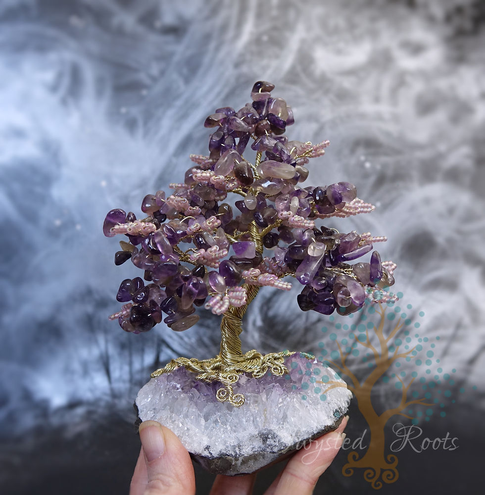 Thumbnail: Hand holding up an amethyst and bead tree on an amethyst crystal base